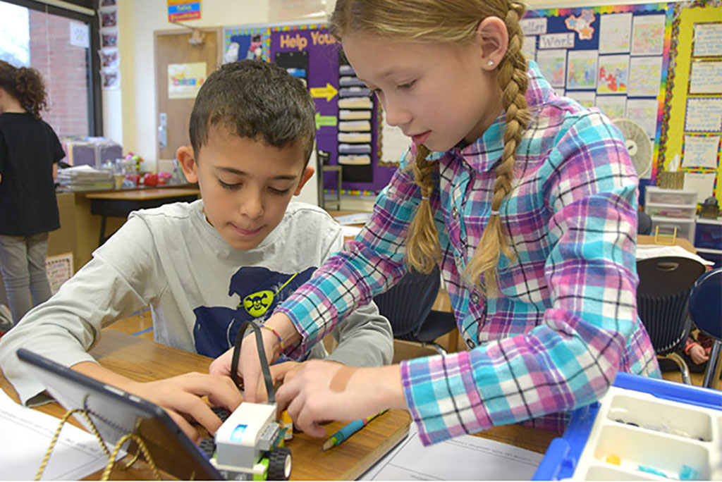 Two students building a robot