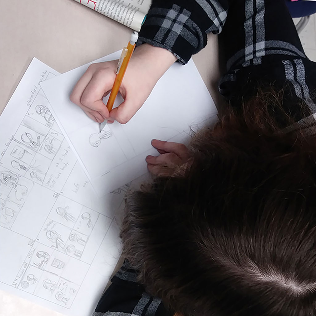 A student drawing a comic strip