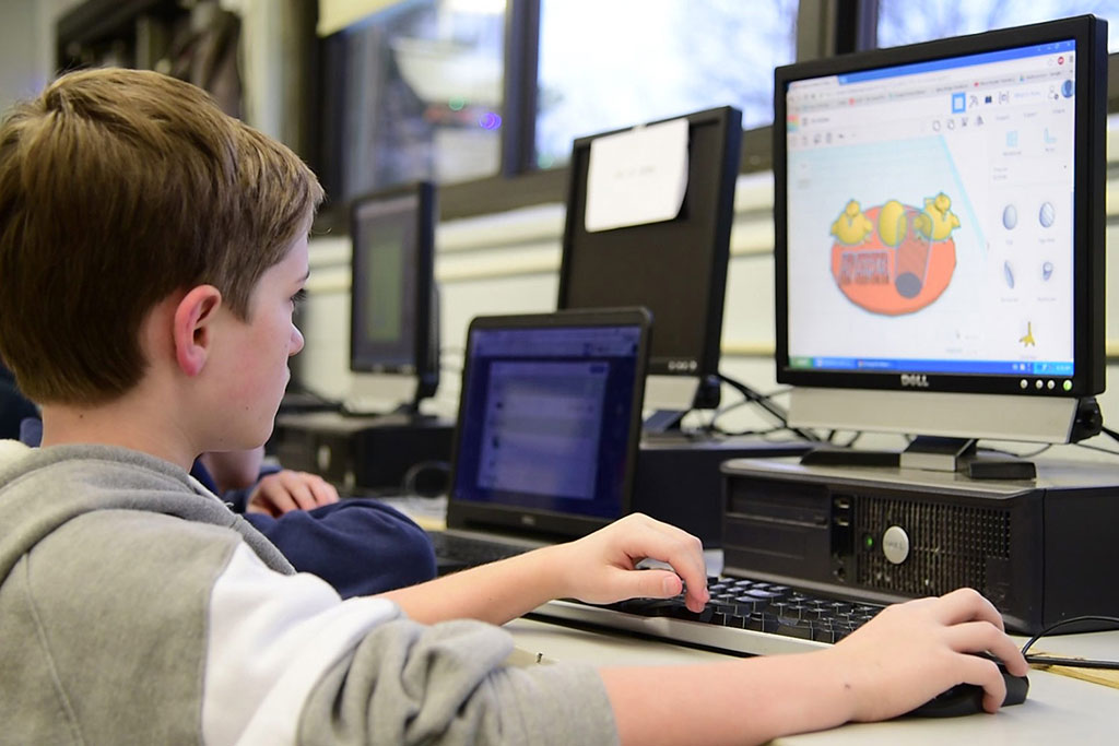 A student designing a robot on their computer