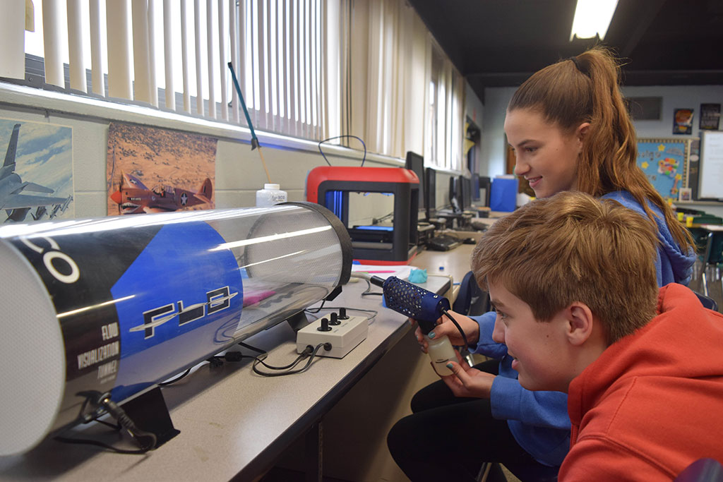 Students observing a wind tunnel